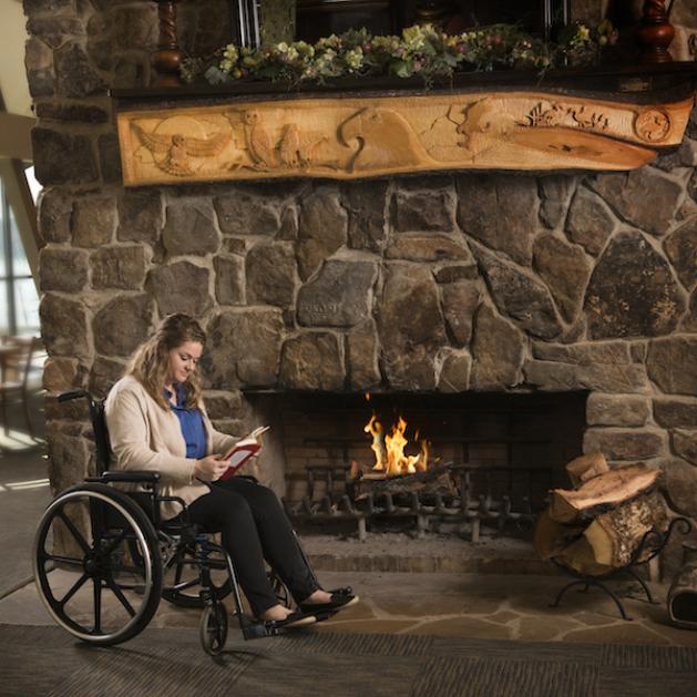 Woman in wheelchair in front of a fireplace ad Degray Lake